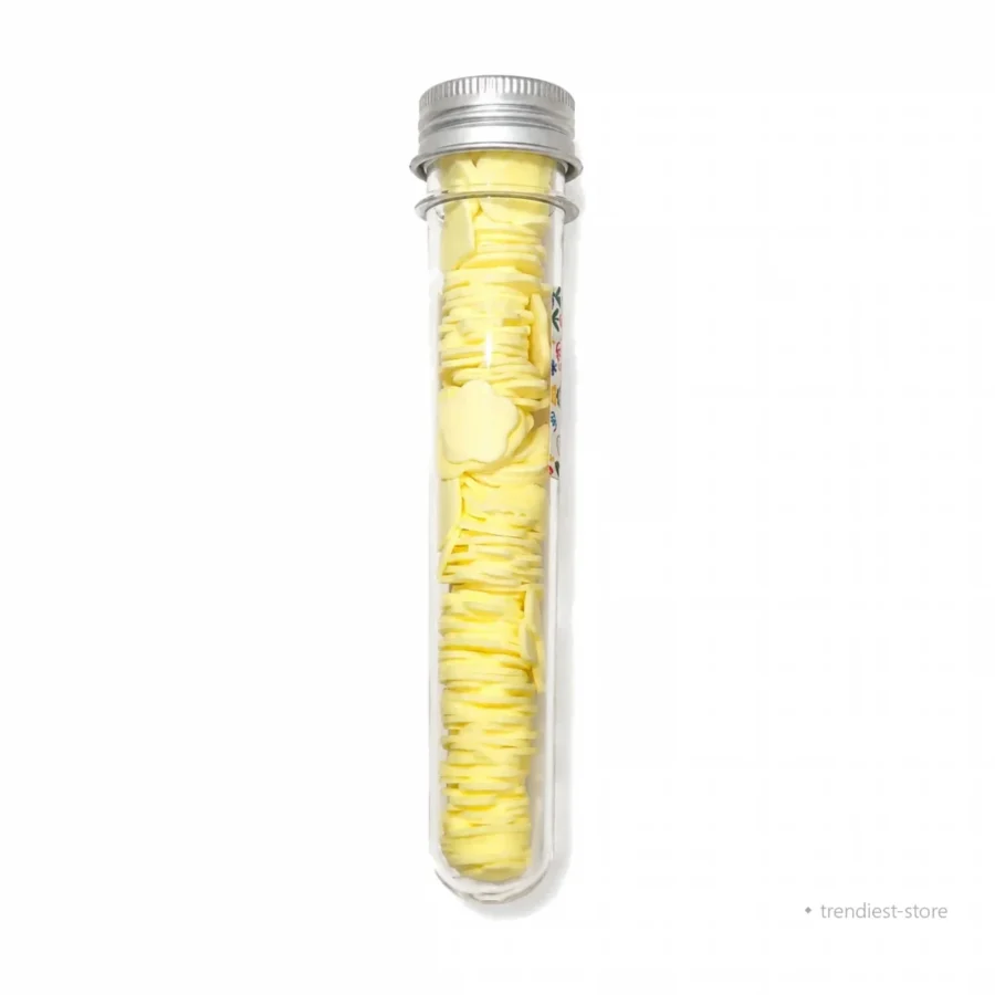 A clear glass test tube with a silver metal screw cap, filled with many small yellow circular discs, shown upright on a plain white background.