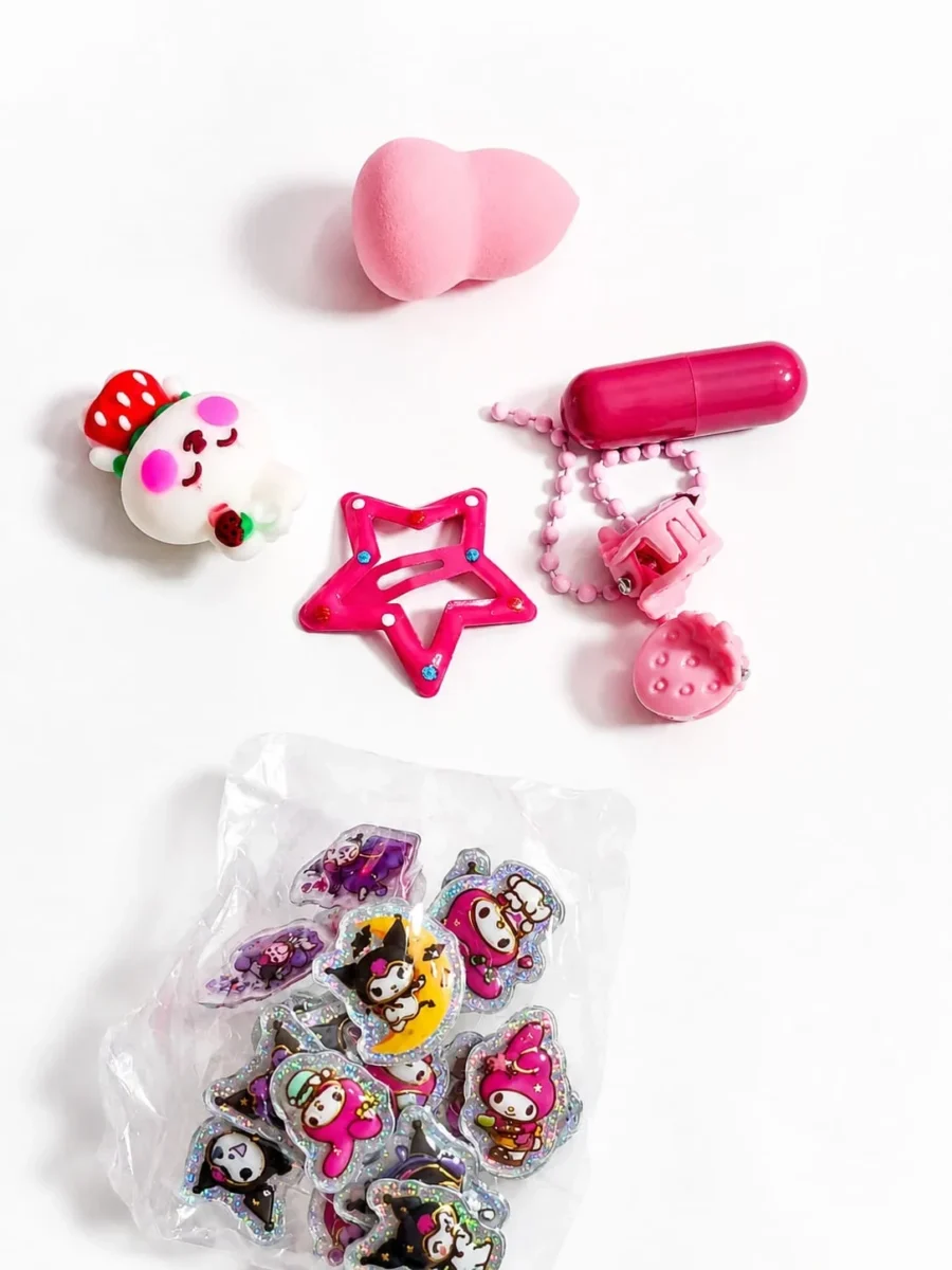 Contents of the mystery box laid out: blender, lip balm, star clip, charm and stickers