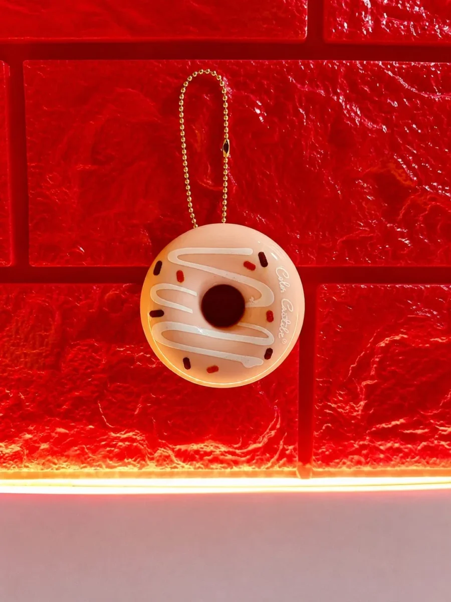 donut lip balm hanging from its gold ball chain keyring
