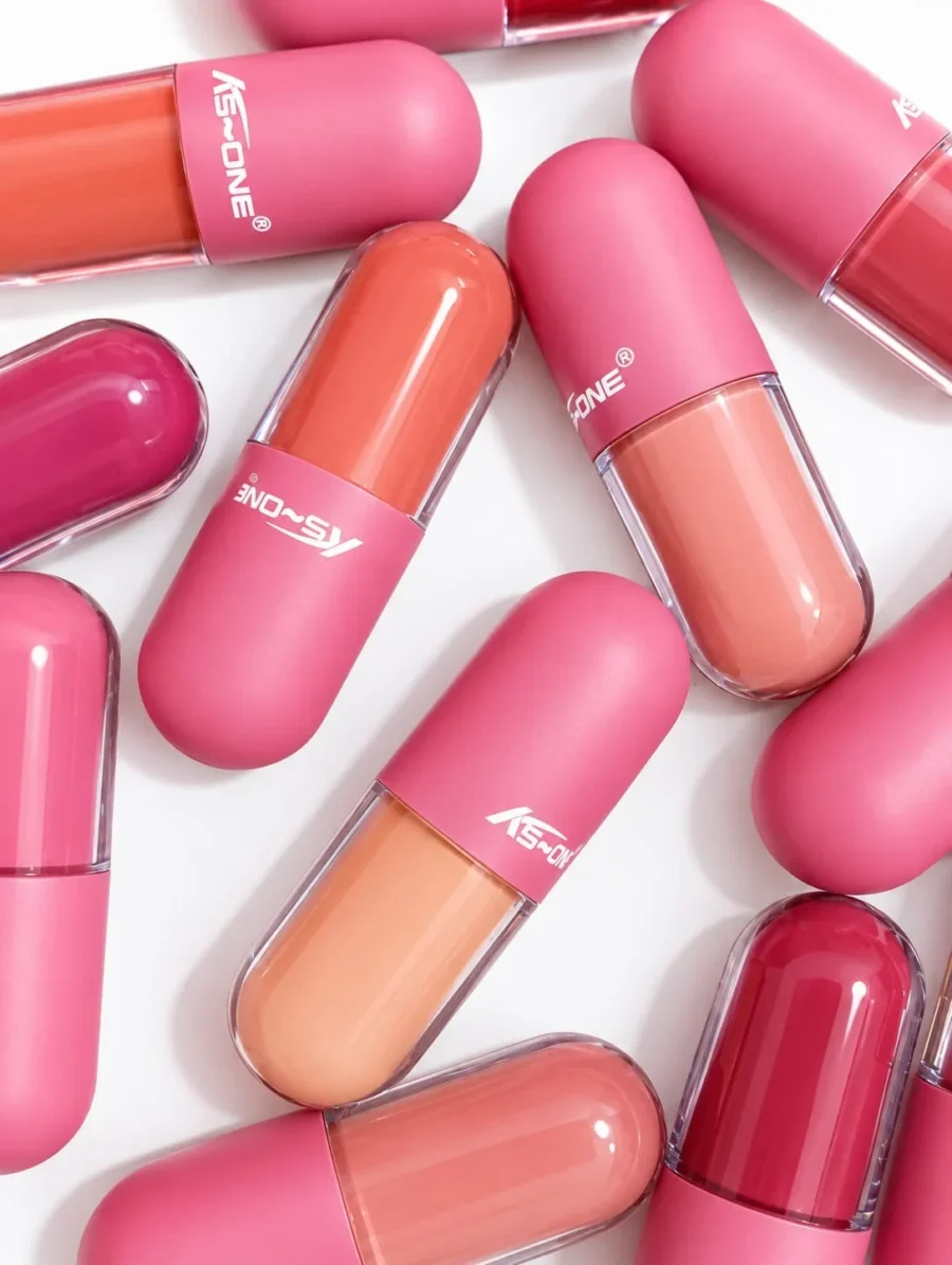 Twelve capsule lip gloss shades laid out in two rows