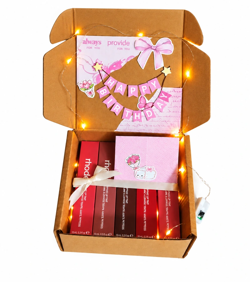 Open lip tint gift box with Happy Birthday bunting, eight lip tint shades and glowing fairy lights